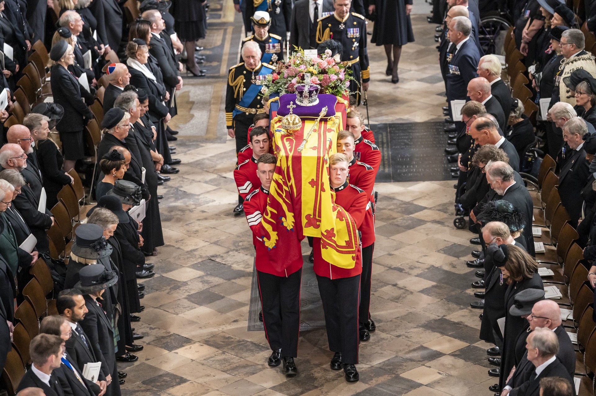 The coffin of Elizabeth II, adorned with the royal standard with the Imperial State Crown and the monarch's orb and sceptre, is carried out of Westminster Abbey after her state funeral (Danny Lawson/PA). 