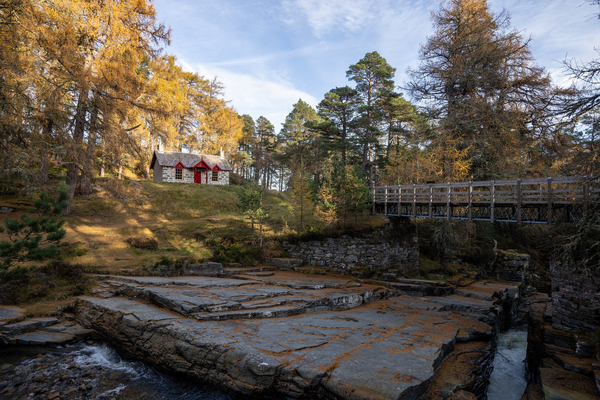 The cottage sits in woodland next to a stream 