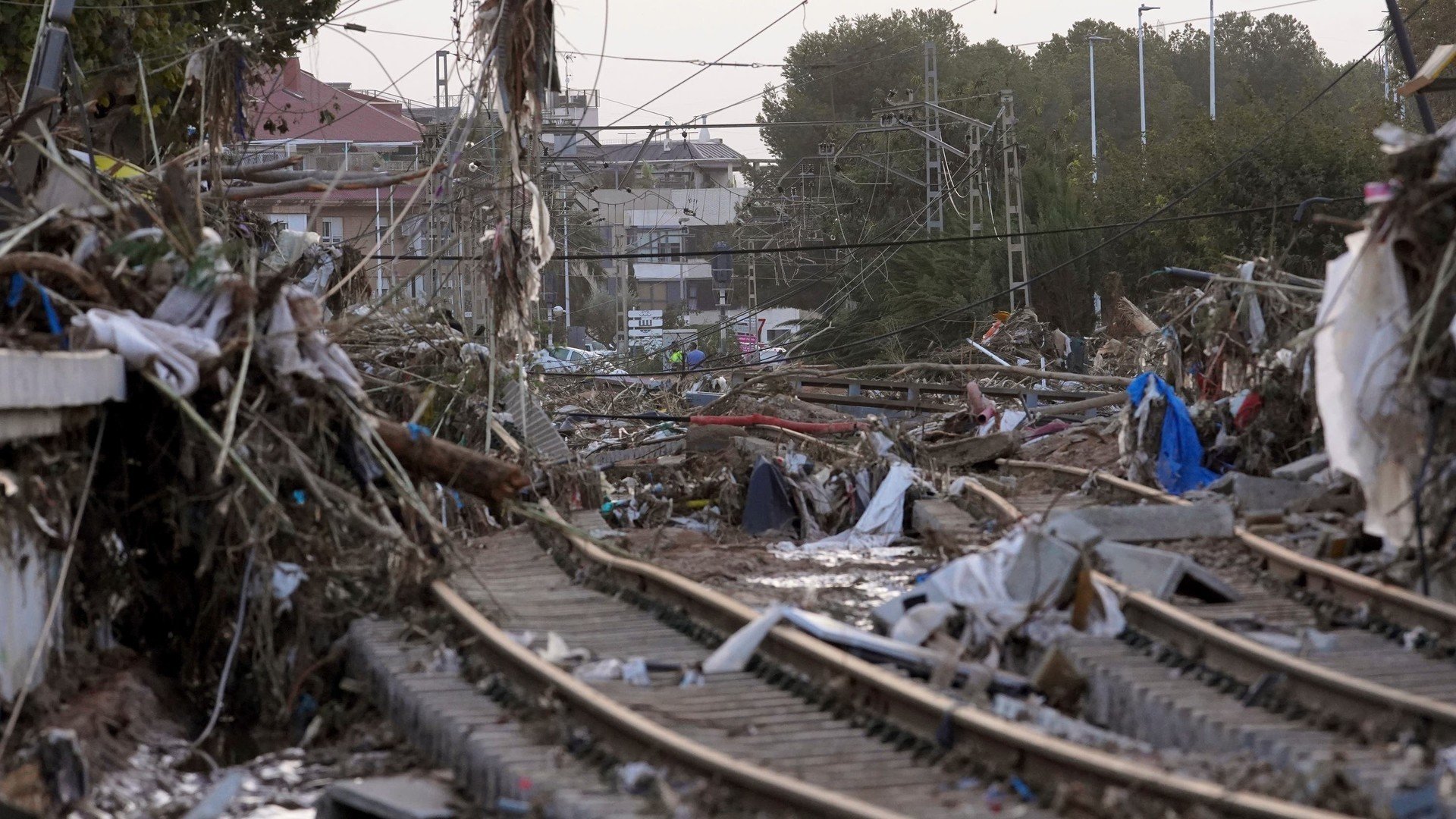 <em>Train tracks are seen affected by floods in Paiporta, near Valencia </em>”/><cite class=cite>PA Media</cite></div><figcaption aria-hidden=true><em>Train tracks are seen affected by floods in Paiporta, near Valencia </em> <cite class=hidden>PA Media</cite></figcaption></figure><p>In Paiporta, mayor Maribel Albalat said Thursday that at least 62 people had perished in the community of 25,000 next to Valencia city.</p><p>“(Paiporta) never has floods, we never have this kind of problem.</p><p>“And we found a lot of elderly people in the town centre,” Ms Albalat told RTVE.</p><p>“There were also a lot of people who came to get their cars out of their garages … it was a real trap.”’</p><p>While the most suffering was inflicted on municipalities near the city of Valencia, the storms unleashed their fury over huge swathes of the south and eastern coast of the Iberian peninsula.</p><p>Two fatalities were confirmed in the neighbouring Castilla La Mancha region and one in southern Andalusia.</p><p>Greenhouses and farms across southern Spain, known as Europe’s garden for its exported produce, were also ruined by heavy rains and flooding.</p><p>The storms spawned a freak tornado in Valencia and a hail storm that punched holes in cars in Andalusia.</p><p>Homes were left without water as far southwest as Malaga in Andalusia.</p><p>Heavy rains continued Thursday farther north as the Spanish weather agency issued alerts for several counties in Castellon, in the eastern Valencia region, and for Tarragona in Catalonia, as well as southwest Cadiz.</p><p>“This storm front is still with us,” the prime minister said.</p><p>“Stay home and heed the official recommendation and you will help save lives.”</p><p>As the shock dissipated, anger grew over the authorities’ handling of the crisis, both for their late warnings of the looming floods and the chaotic relief response.</p><p>Many survivors had to walk long distances in sticky mud to find food and water.</p><p>Most of their cars had been destroyed and the mud, destruction and debris left by the storm made some roads unpassable.</p><p>Some pushed shopping carts along sodden streets while others carried their children to keep them out of the muck.</p><p>Some 150,000 people in Valencia were without electricity on Wednesday, but roughly half had power by Thursday.</p><p>An unknown number did not have running water and were relying on whatever bottled water they could find.</p><p>The region remained partly isolated with several roads cut off and train lines interrupted, including the high-speed service to Madrid.</p><p>Officials said it would take two to three weeks to repair that damaged line.</p><p>And with emergency personnel focused on recovering the dead, survivors were left to find basic supplies and clean up the mess.</p><p>Volunteers joined locals in moving wrecked vehicles, removing junk and sweeping mud.</p><p>With local services clearly overwhelmed, Valencia regional President Carlos Mazon on Thursday asked if Spain’s army could assist with distributing basic goods to the population.</p><p>The government in Madrid responded by promising to send in 500 more soldiers, more national police and Civil Guards.</p><p>But necessity — and the post-apocalyptic atmosphere — prompted some to enter abandoned stores.</p><p>The National Police arrested 39 people for looting on Wednesday.</p><p>The Civil Guard said it detained 11 people for thefts in shopping malls, while its officers were also deployed to stop people stealing from cars.</p><p>Some people said they had to steal supplies, especially those who have no running water or a way to get to stores that were not wrecked.</p><p>“We are not thieves. I work as a cleaner at the school for the council. But we have to eat. Look at what I’m picking up: baby food for the baby,” said Nieves Vargas in a local supermarket whose doors had been tossed aside by the water and was unattended by staff.</p><p>“What can I give to the child, if we don’t have electricity.”</p><div class=