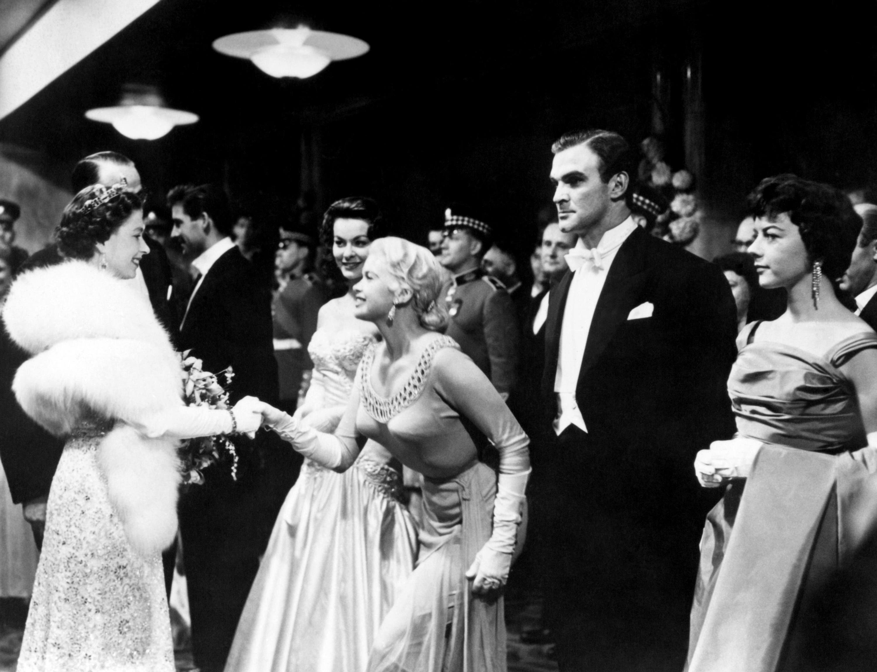 Queen Elizabeth II shakes hands with Hollywood actress Jayne Mansfield at the Royal Film Performance of Les Girls at the Odeon in Leicester Square in 1957 (PA) 