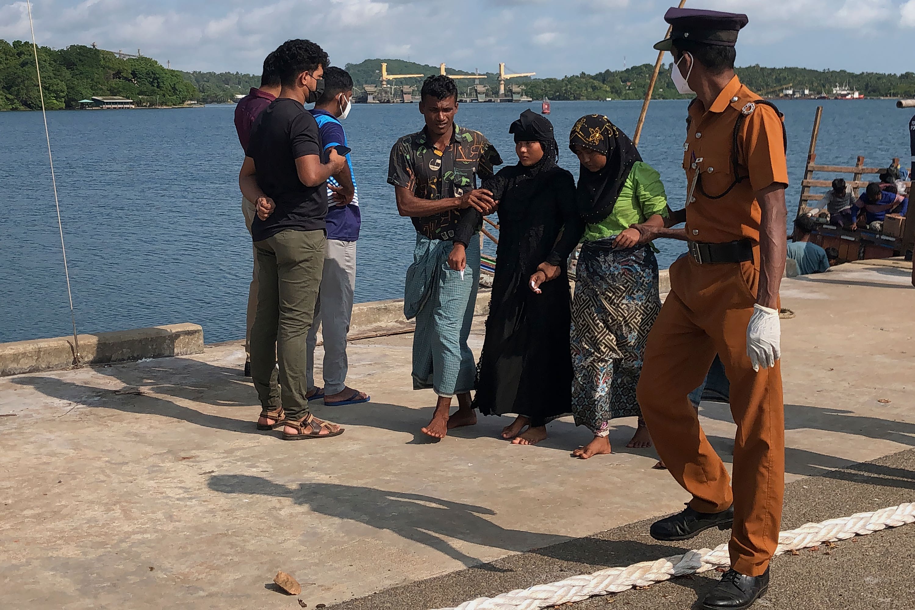 Two women and a man, believed to be Rohingya refugees, arrive at a port in Trincomalee, Sri Lanka (Mangalanath Liyanaarahhi/AP) 