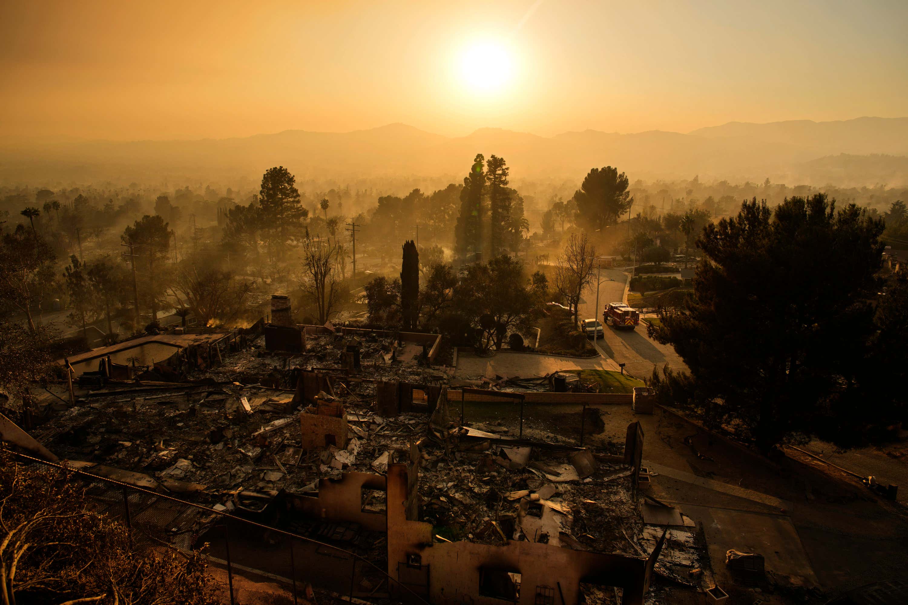 An emergency vehicle drives through a neighbourhood devastated by the Eaton fire in Altadena, California (John Locher/AP). 