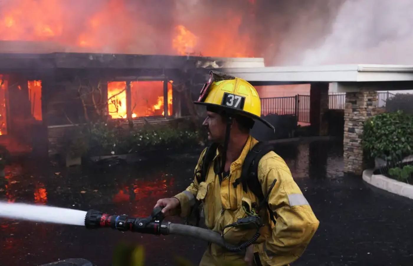 A firefighter battles the Palisades Fire as it burns a residence in the Pacific Palisades neighbourhood of Los Angeles.