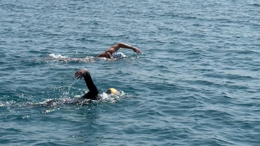 The swimmers are pictured against the Dubai backdrop