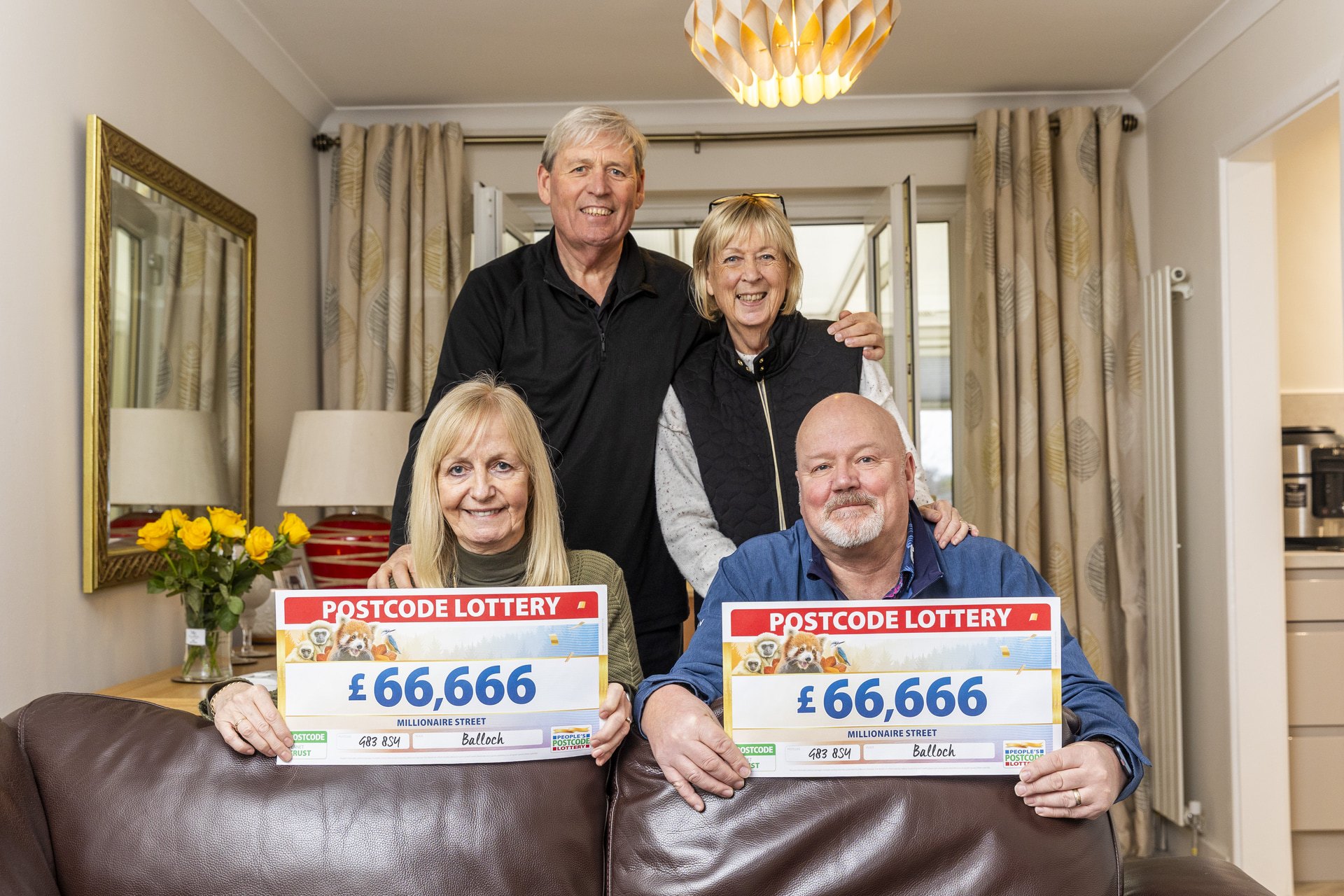 Paul and Kay hold cheques with siblings Alex and Catherine