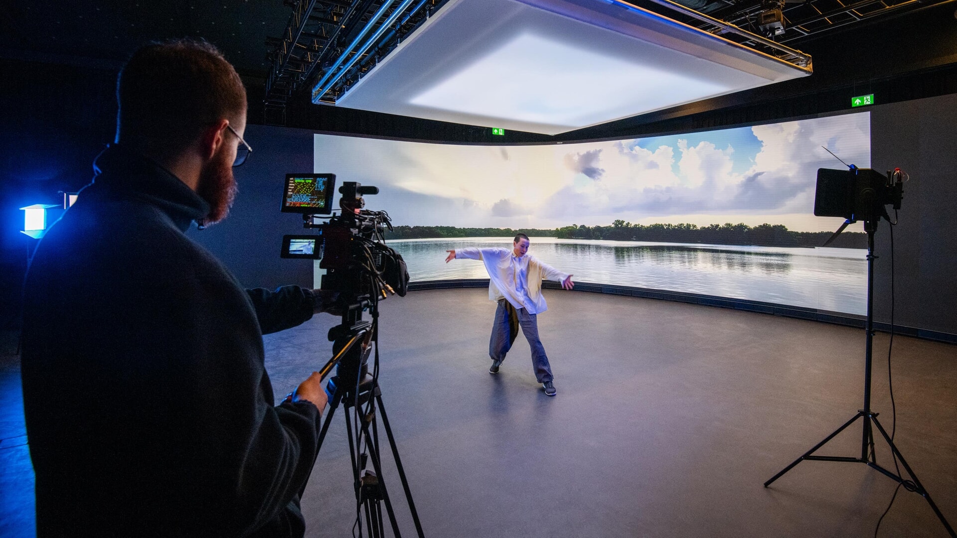 An actor being filmed before a large screen inside the new studio 