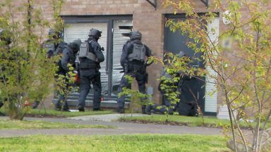 Six arrested in connection with gang war after armed police raid homes