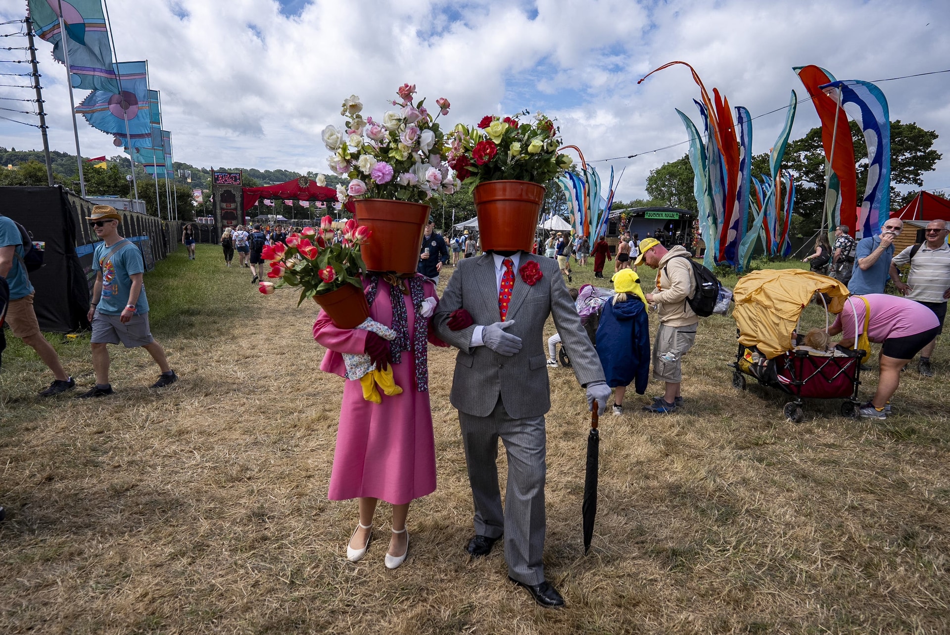People with flowerpots as heads during the Glastonbury Festival (Ben Birchall/PA).