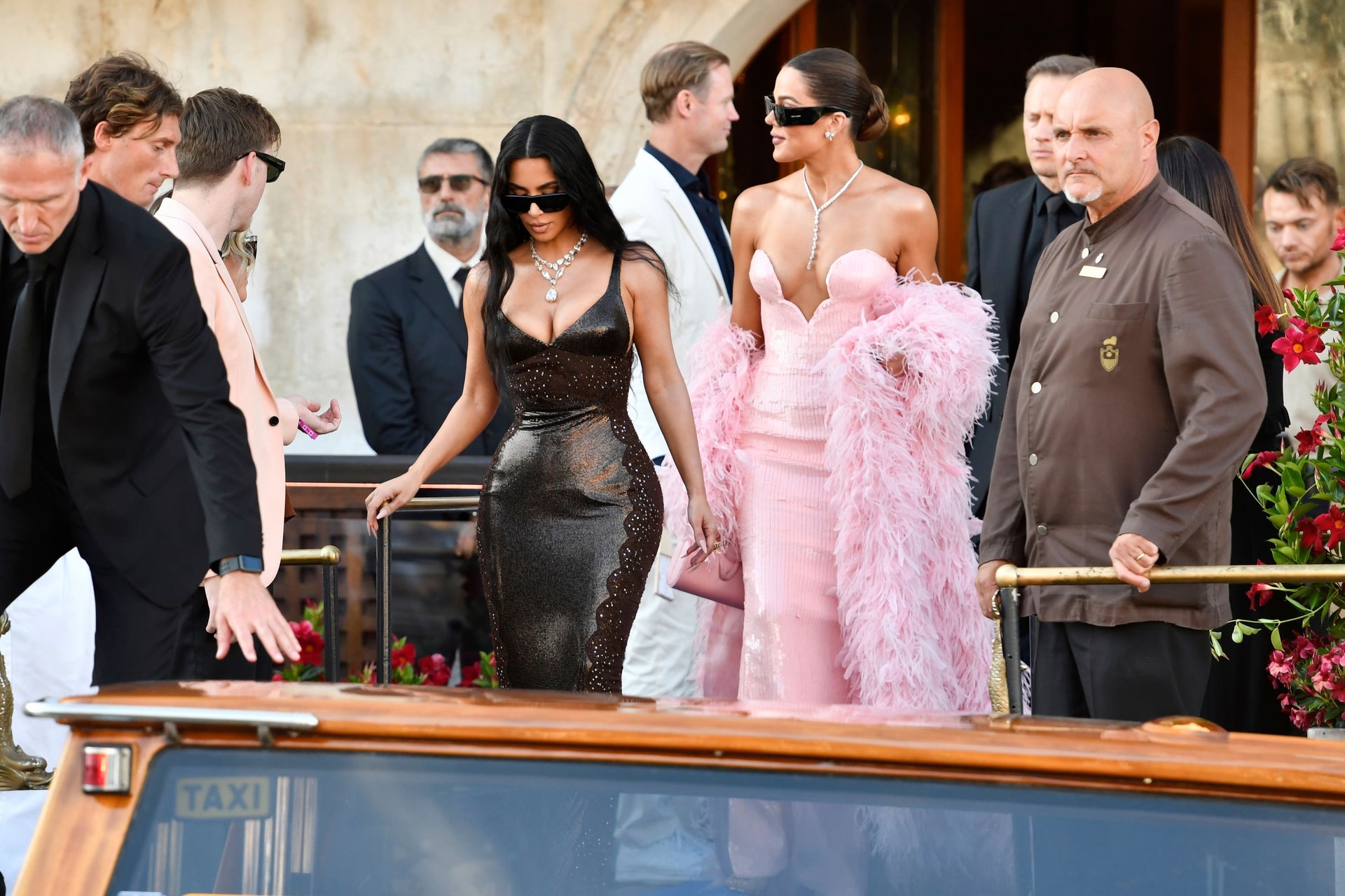 Kim and Khloe Kardashian leave a hotel ahead of the wedding celebrations of Jeff Bezos and Lauren Sanchez (Luigi Costantini/AP).