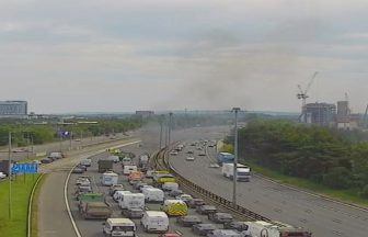 Section of M8 closed after vehicle catches fire as drivers warned of delays