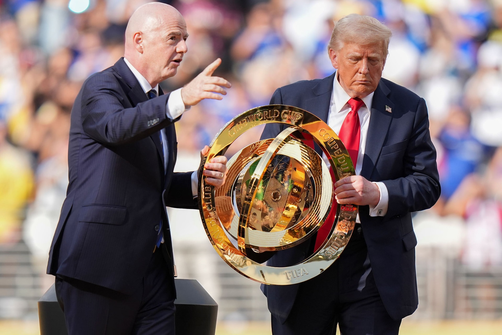 Fifa president Gianni Infantino, left, and US president Donald Trump carried the championship trophy on the pitch (Frank Franklin II/AP).
