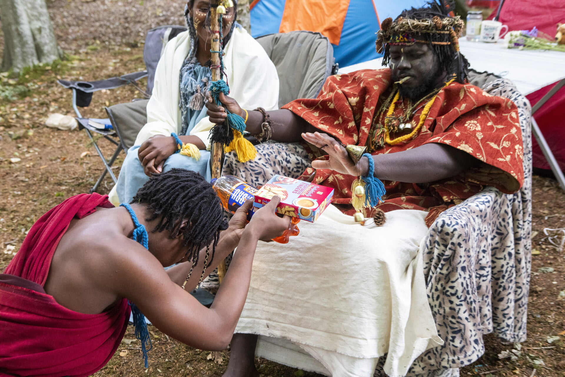 An offering of Irn Bru and shortbread (from a journalist) is brought to King Atehehe.