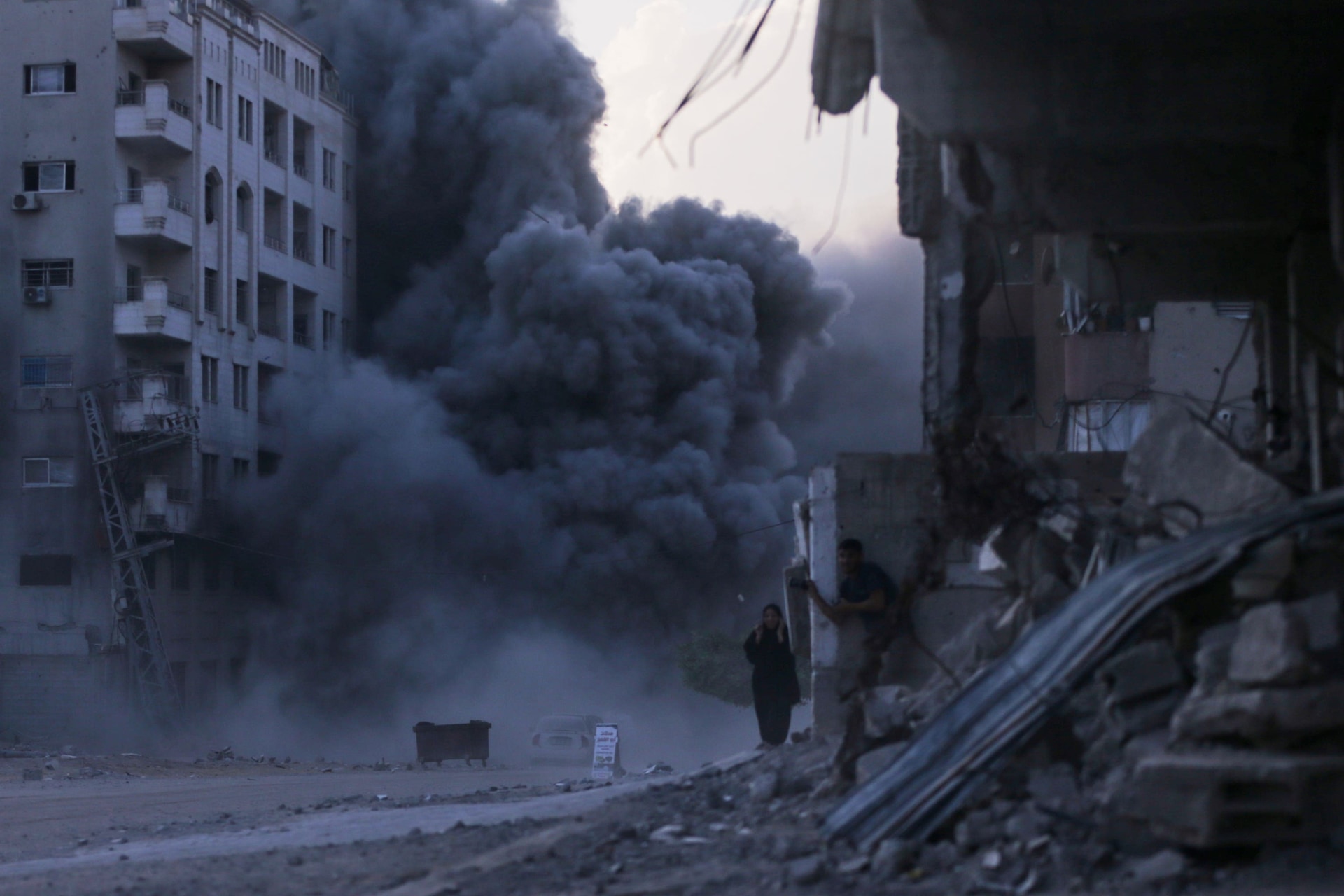 Palestinians take cover during an Israeli strike on a building in Gaza