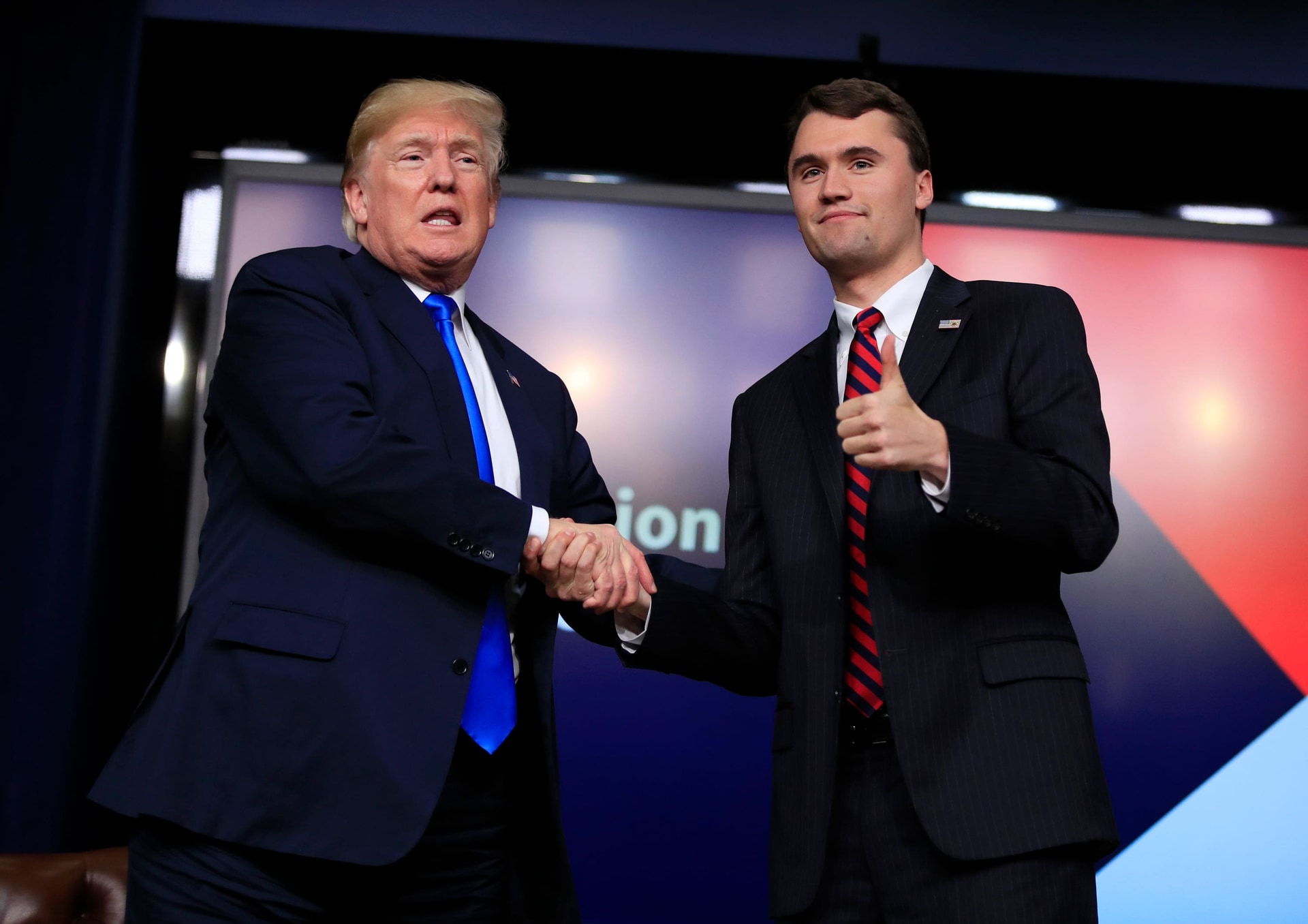 President Donald Trump shakes hands with moderator Charlie Kirk, during a Generation Next White House forum in 2018 (Manuel Balce Ceneta/AP)