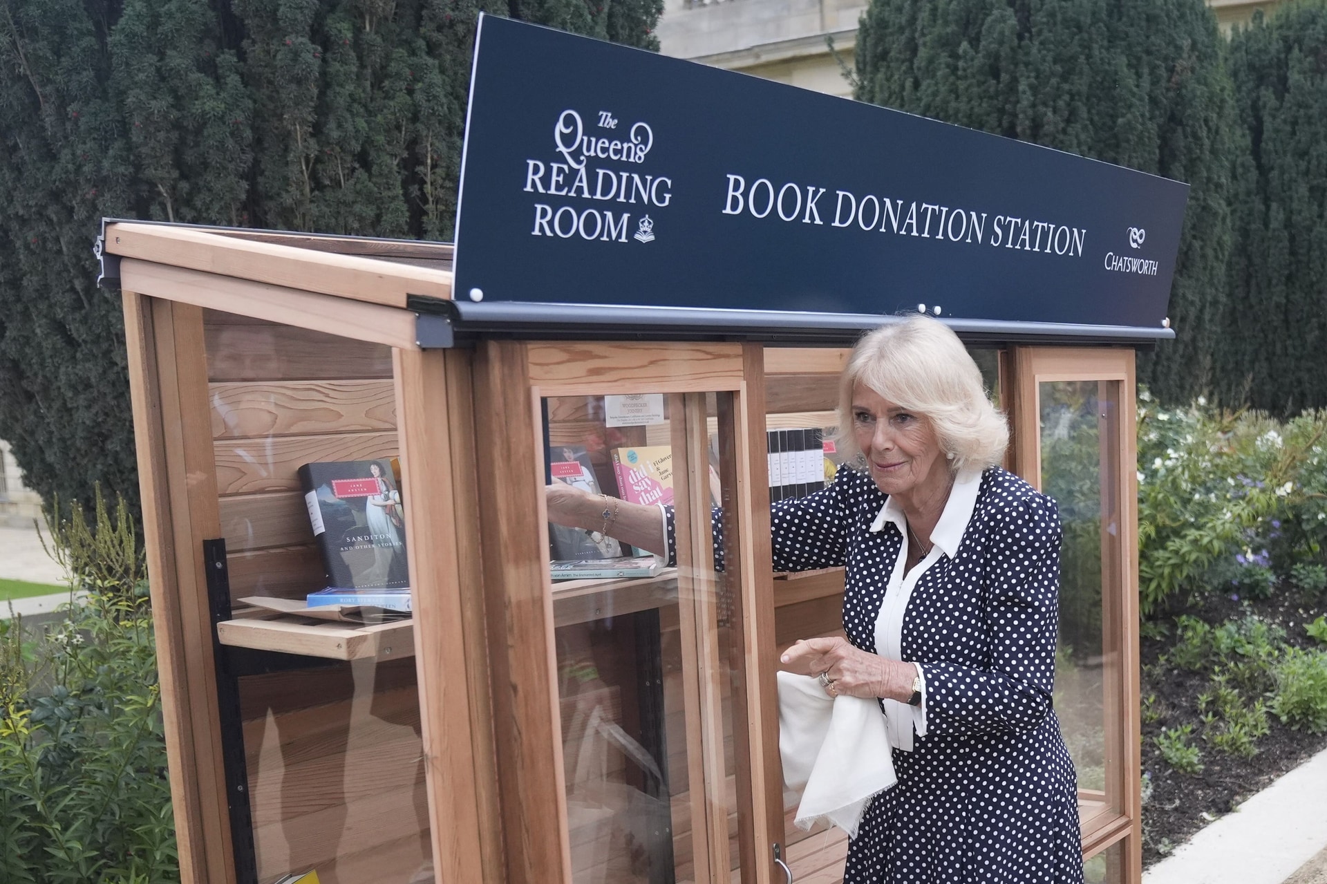 Camilla places books in a donation point for The Queen’s Reading Room (Danny Lawson/PA).