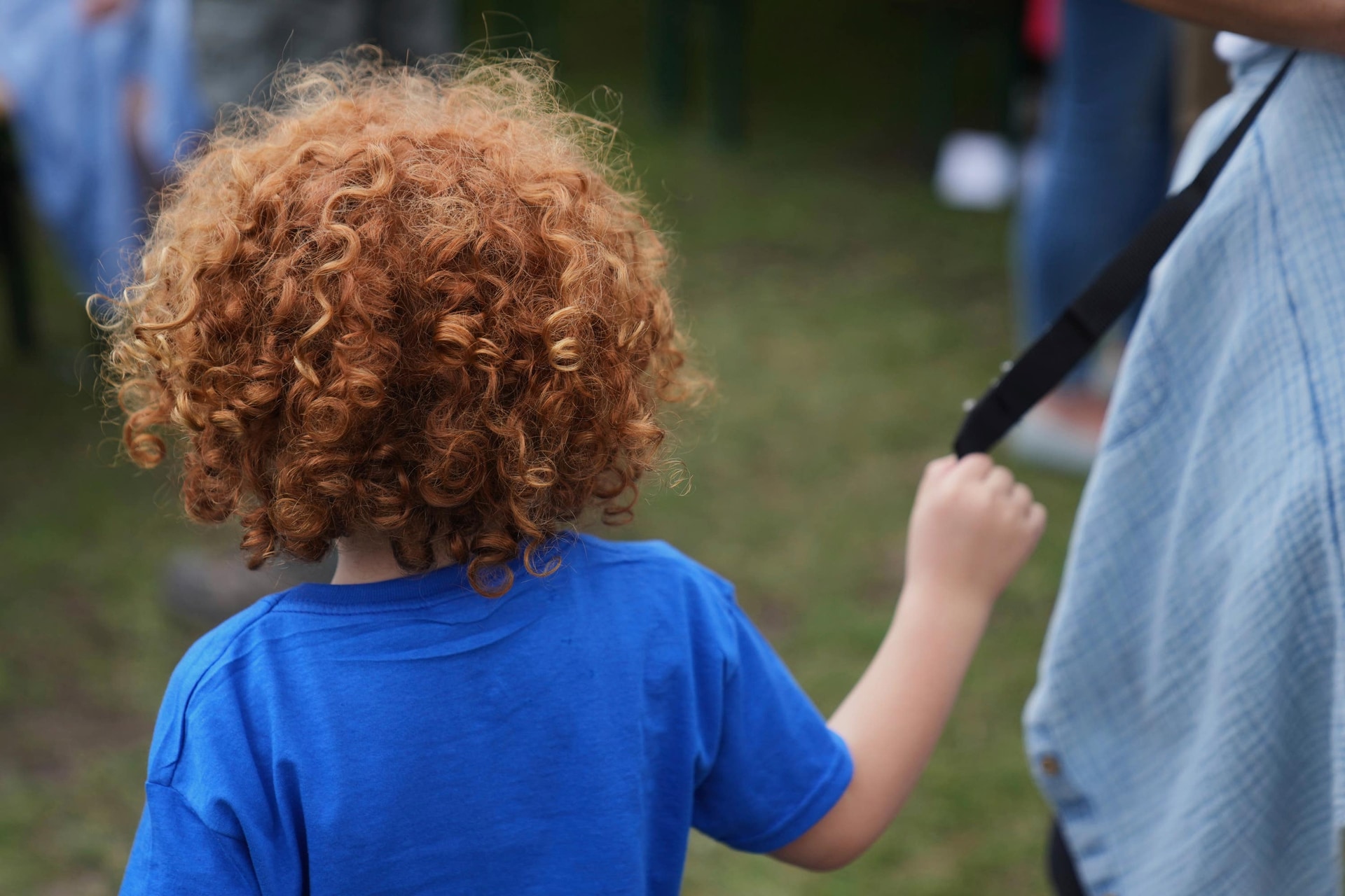 A small boy holds on to his mother during the Red Head Days festival.