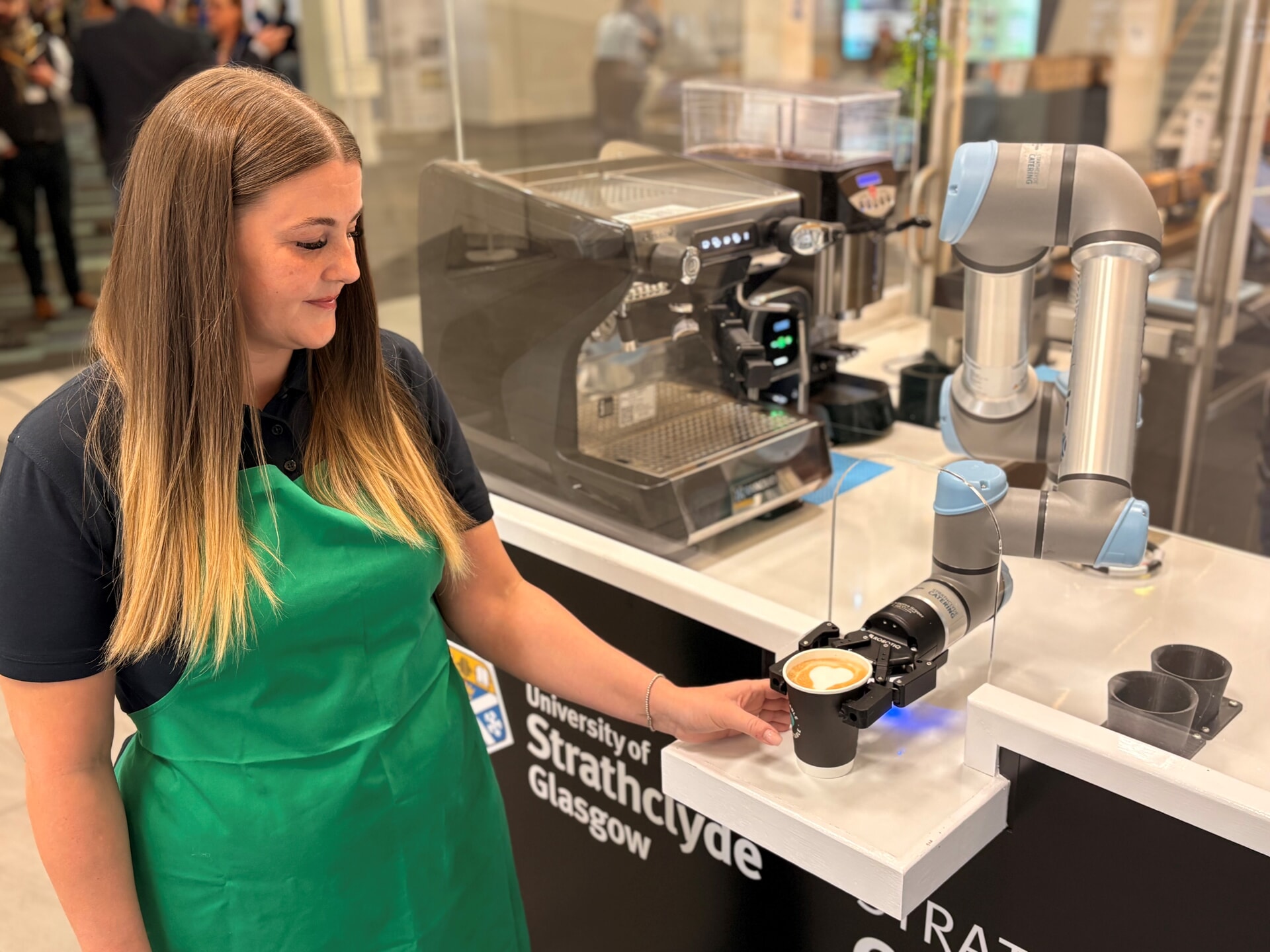 University of Strathclyde Catering food & beverage assistant Donna Bowers with the cobot.