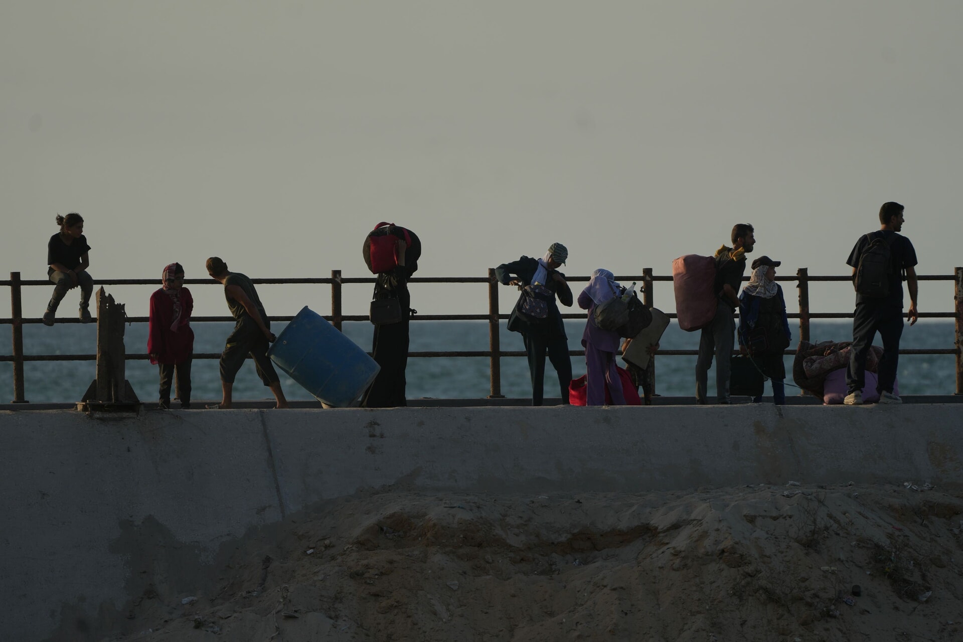 Displaced Palestinians flee northern Gaza carrying their belongings.