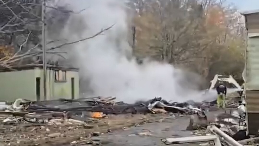 Demolition vehicles razing the structures to the ground.