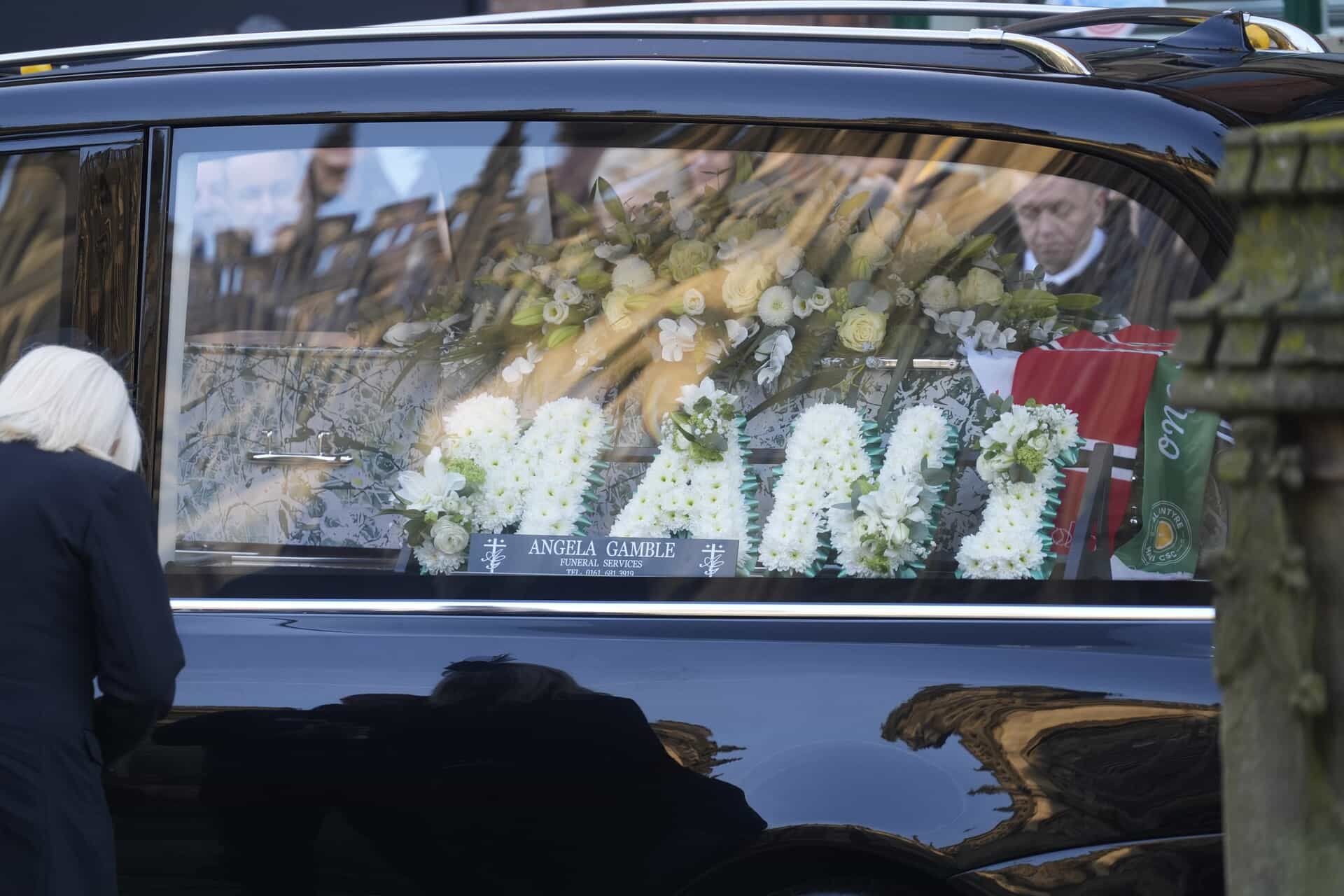 Flowers reading ‘Mani’ in the hearse as it arrives for the funeral service