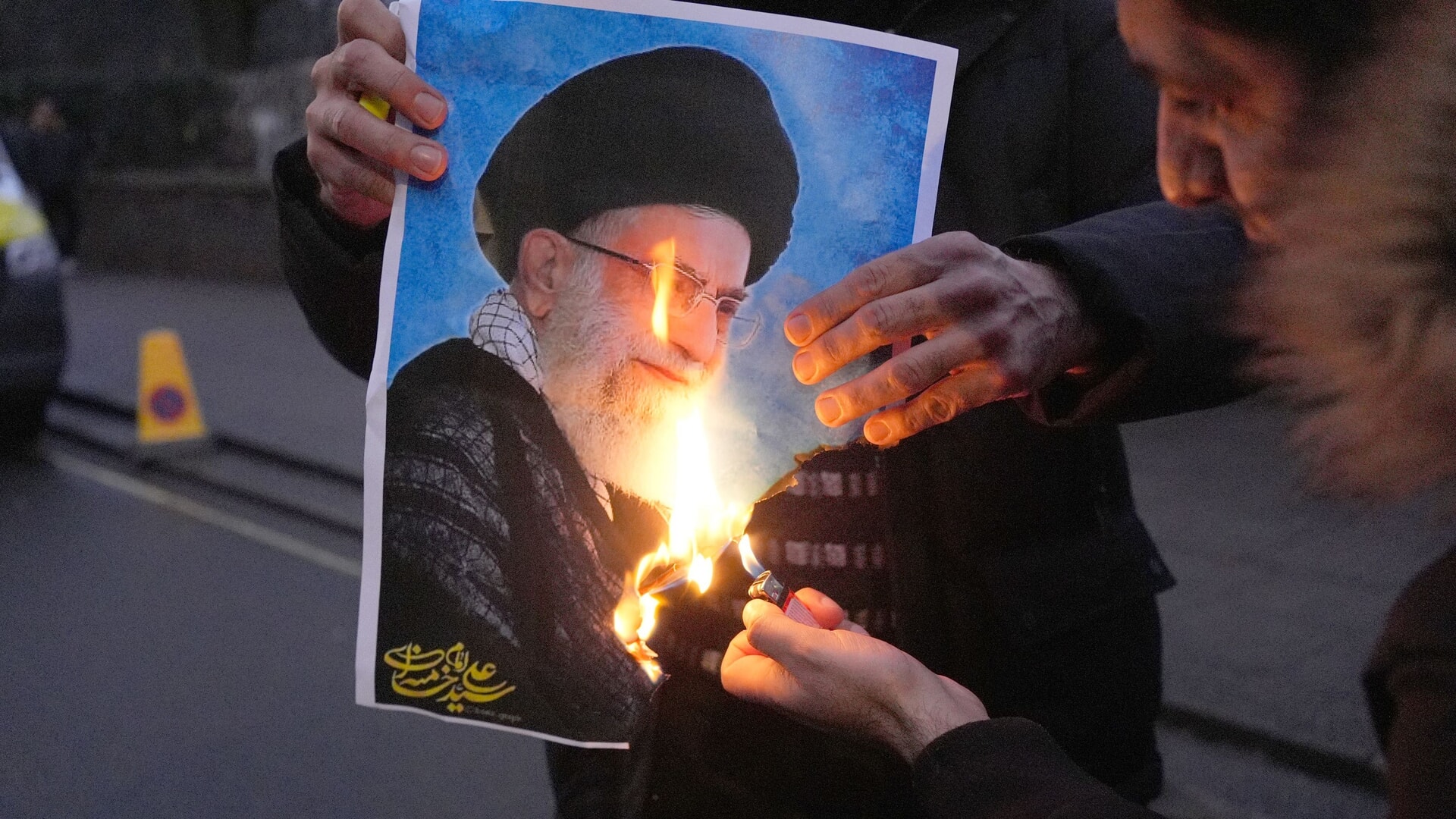 A picture of Iran’s Supreme Leader Ayatollah Ali Khamenei is set alight by a protester outside the Iranian embassy in London.