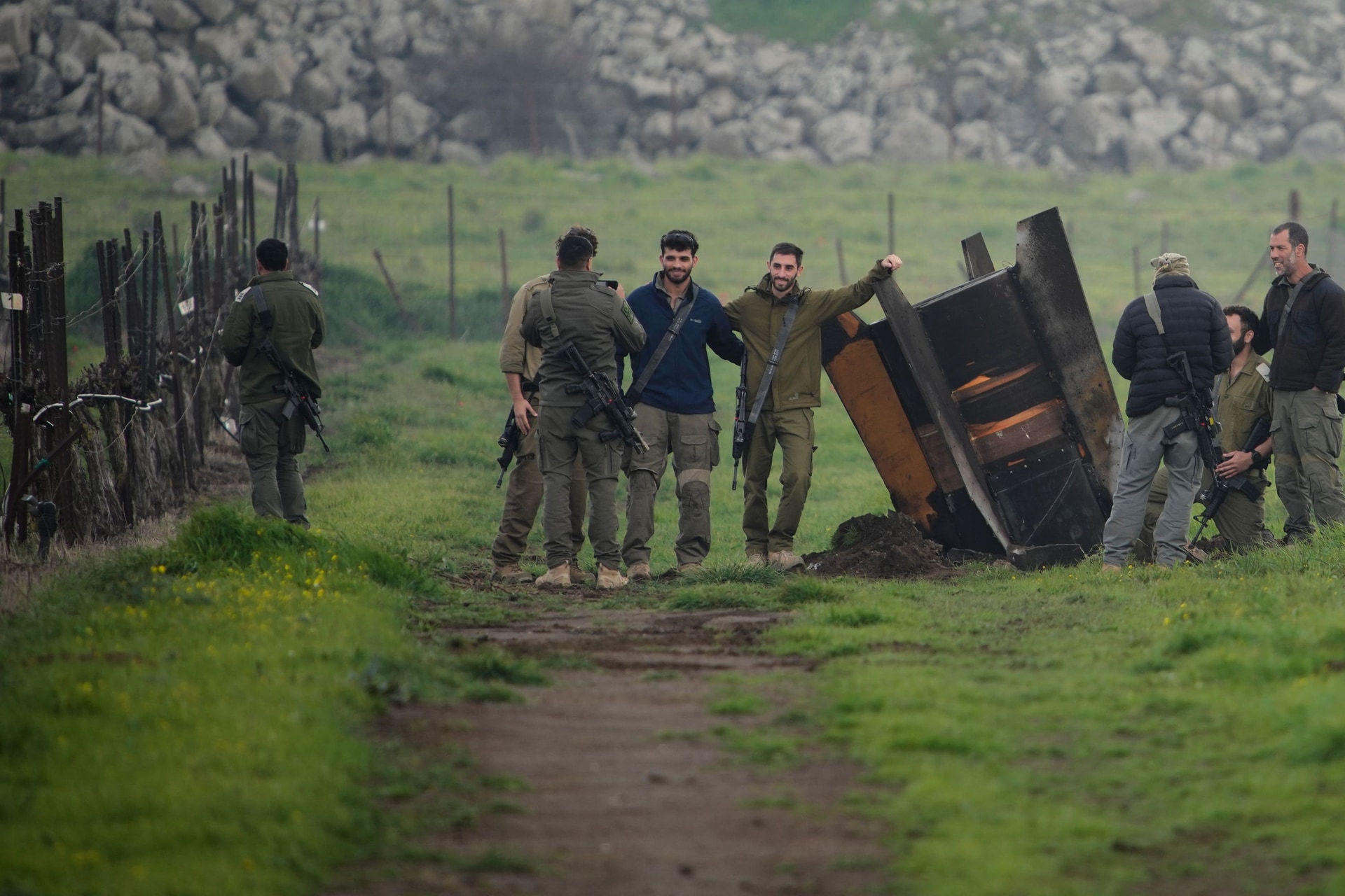 Israeli soldiers take photographs next to a fragment of a missile fired from Iran, and intercepted by the Israeli defence system (Ohad Zwigenberg/AP)