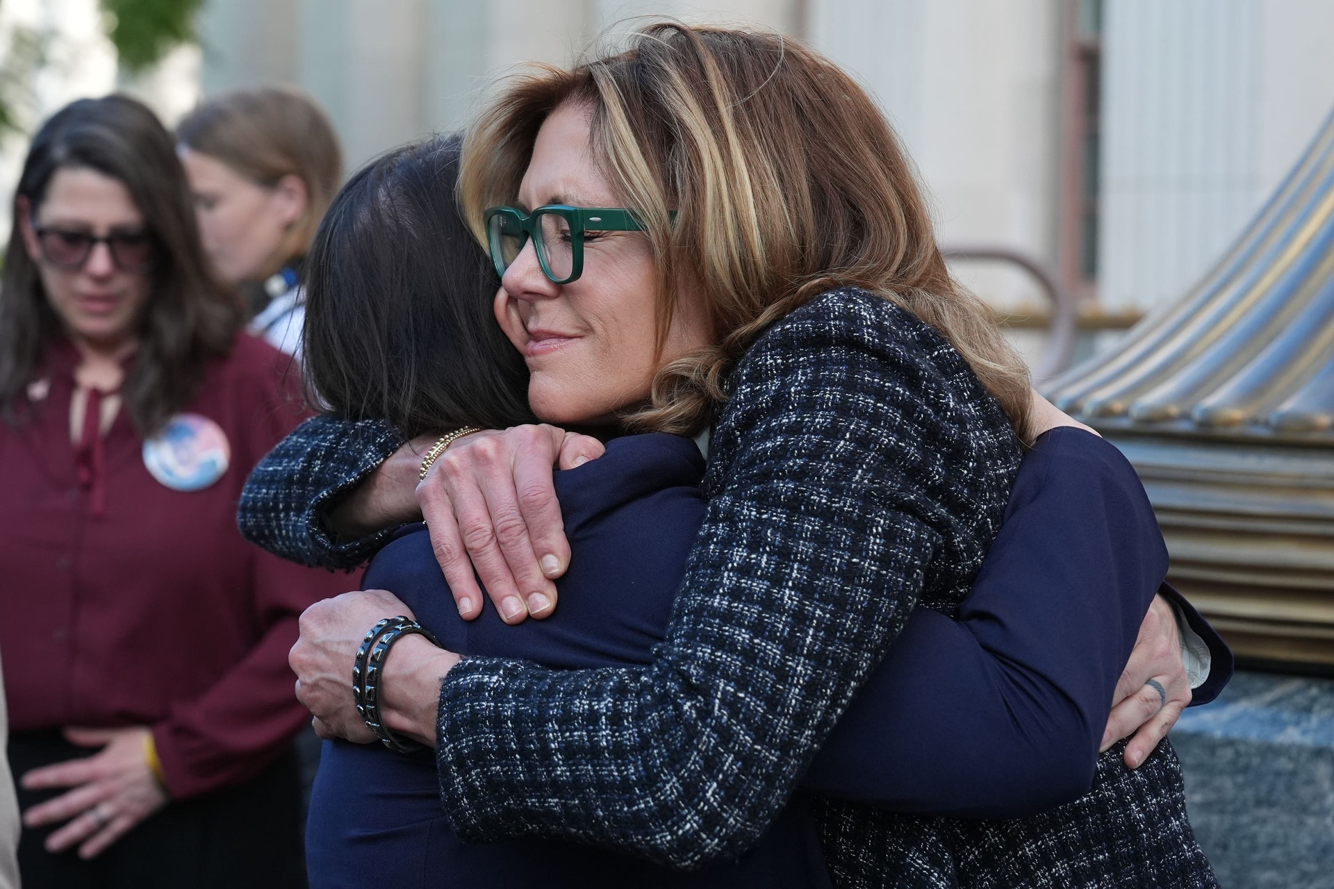 Laura Marquez-Garrett, lawyer for SMVLC, embraces Julianna Arnold, right, a parent, outside Los Angeles Superior Court