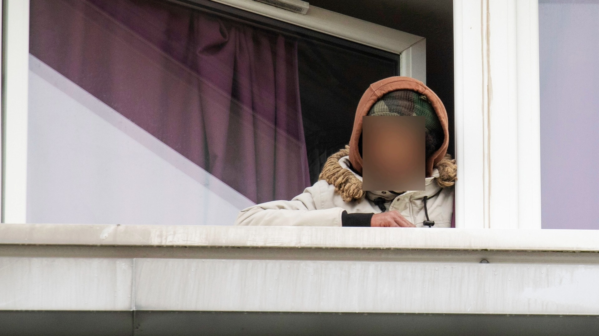 Suspect looking out from an 11th floor flat of a tower block in the Calders, Edinburgh