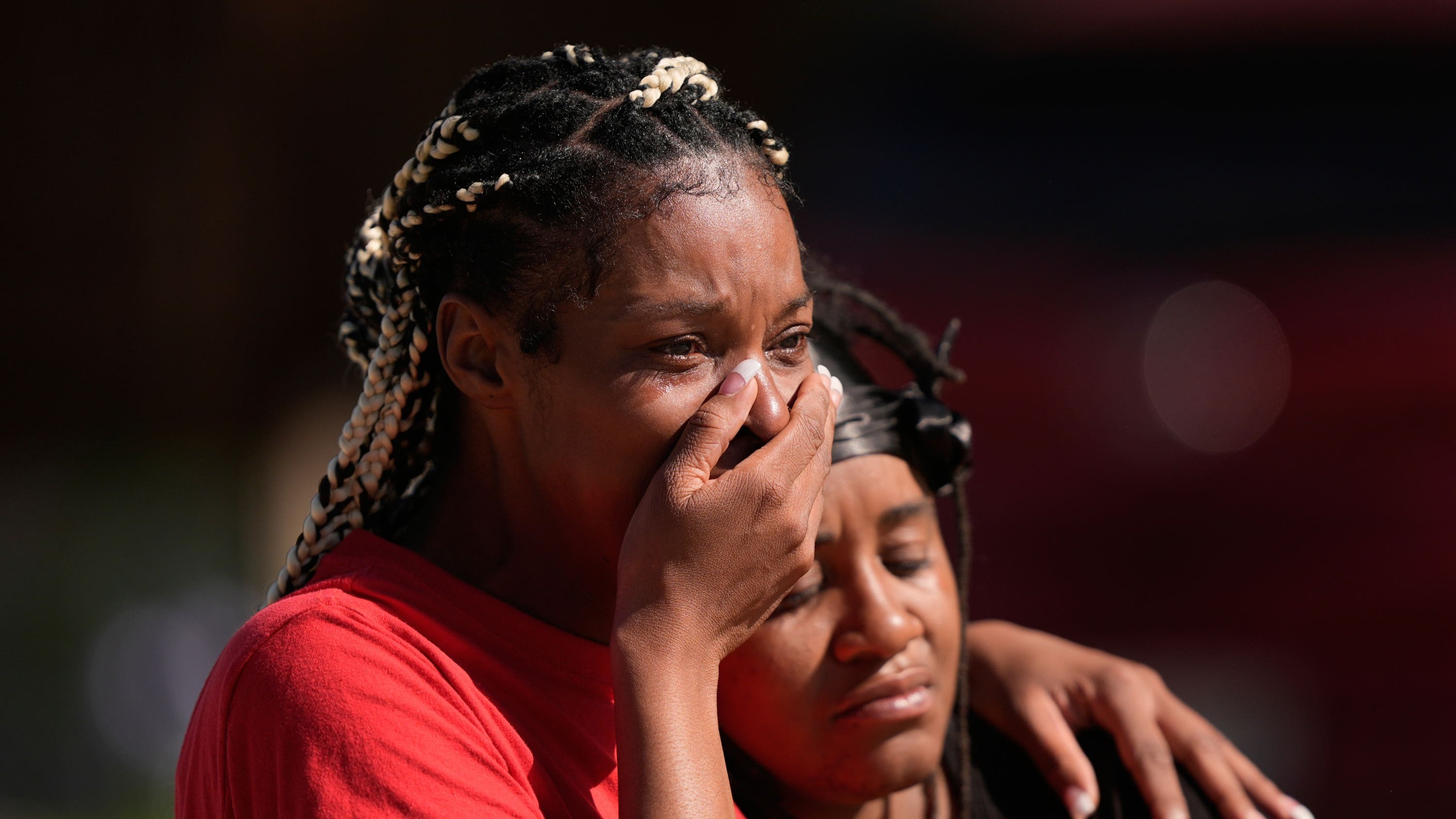 People grieve as they comfort each other outside the scene of a mass shooting in Louisiana