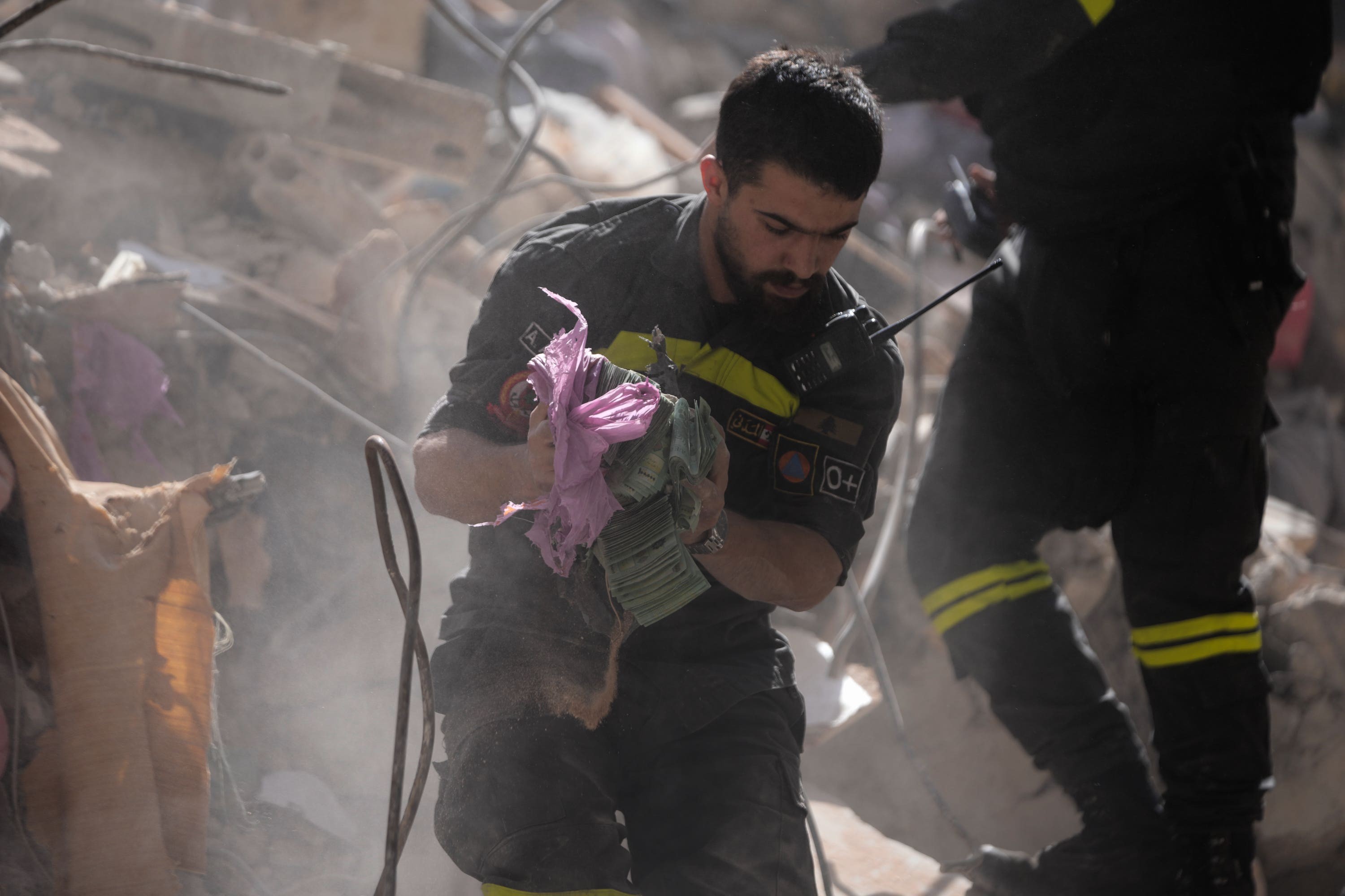 A rescue worker holds money recovered from the rubble of a destroyed building in Beirut on Thursday
