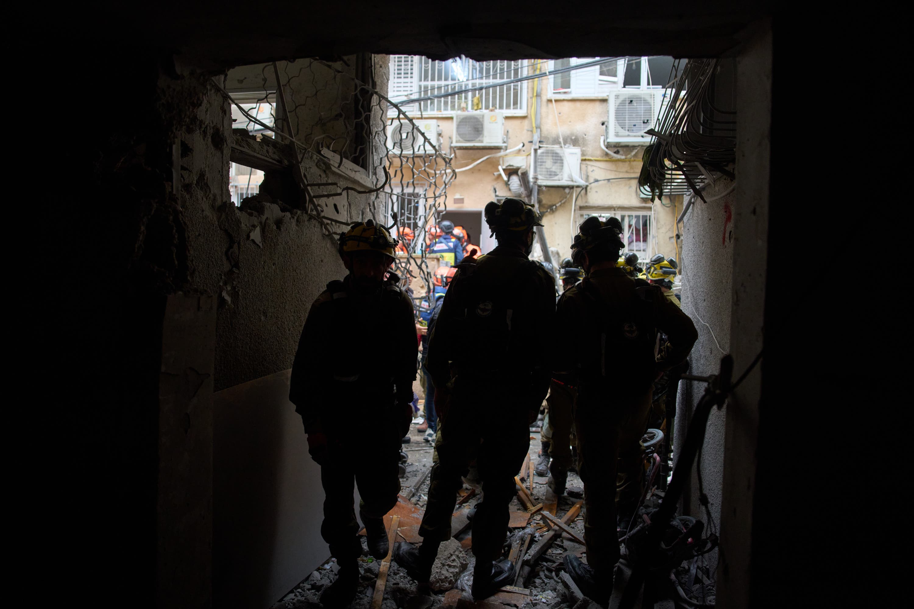 Israeli security forces and rescue teams inspect a site struck by an Iranian missile in Bnei Brak, Israel