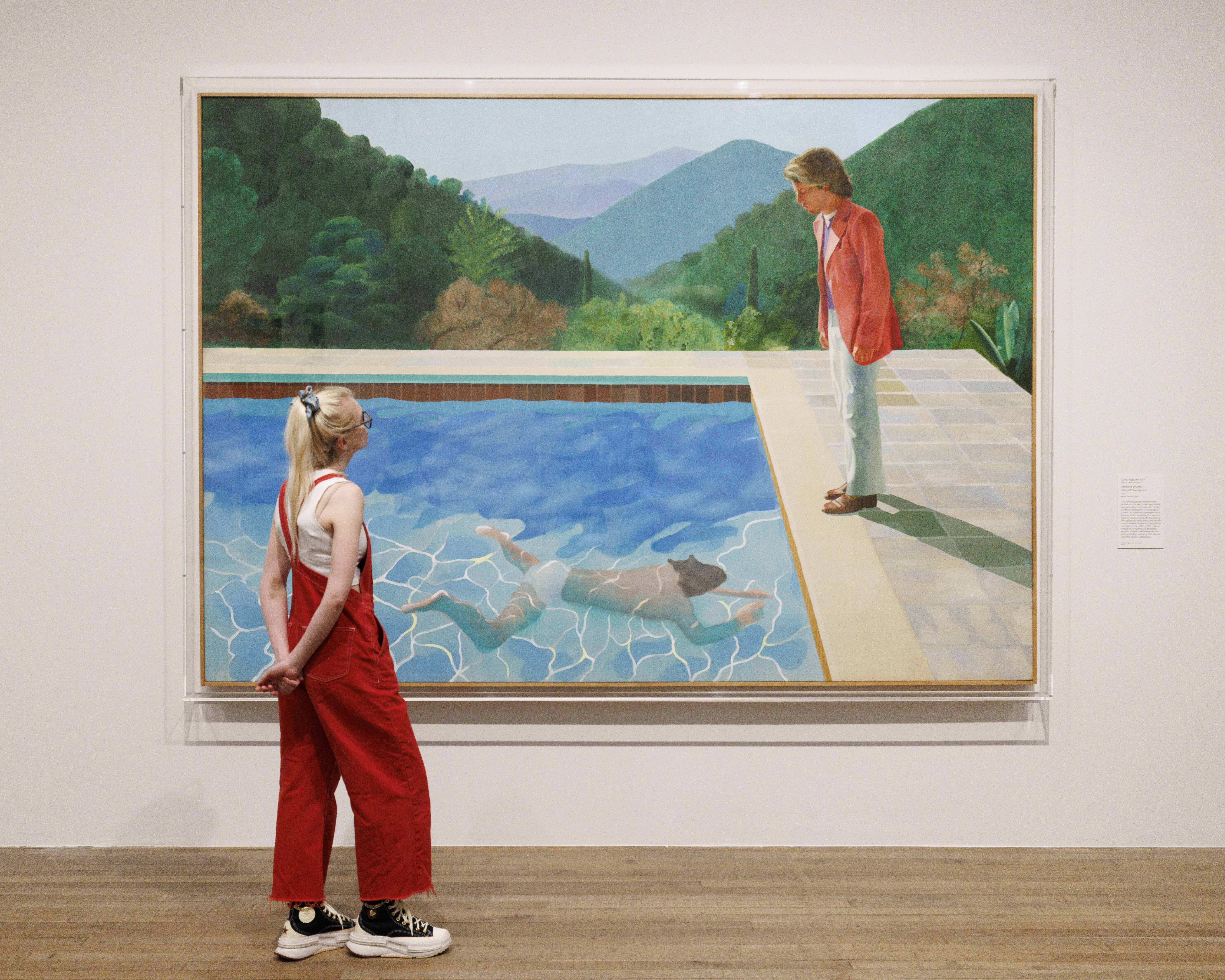 A person looks at David Hockney's, Portrait of an Artist (Pool with Two Figures), 1972, during a photo call for London's Tate Modern's new Capturing the Moment exhibition, which includes works by Andy Warhol, Picasso and Francis Bacon.