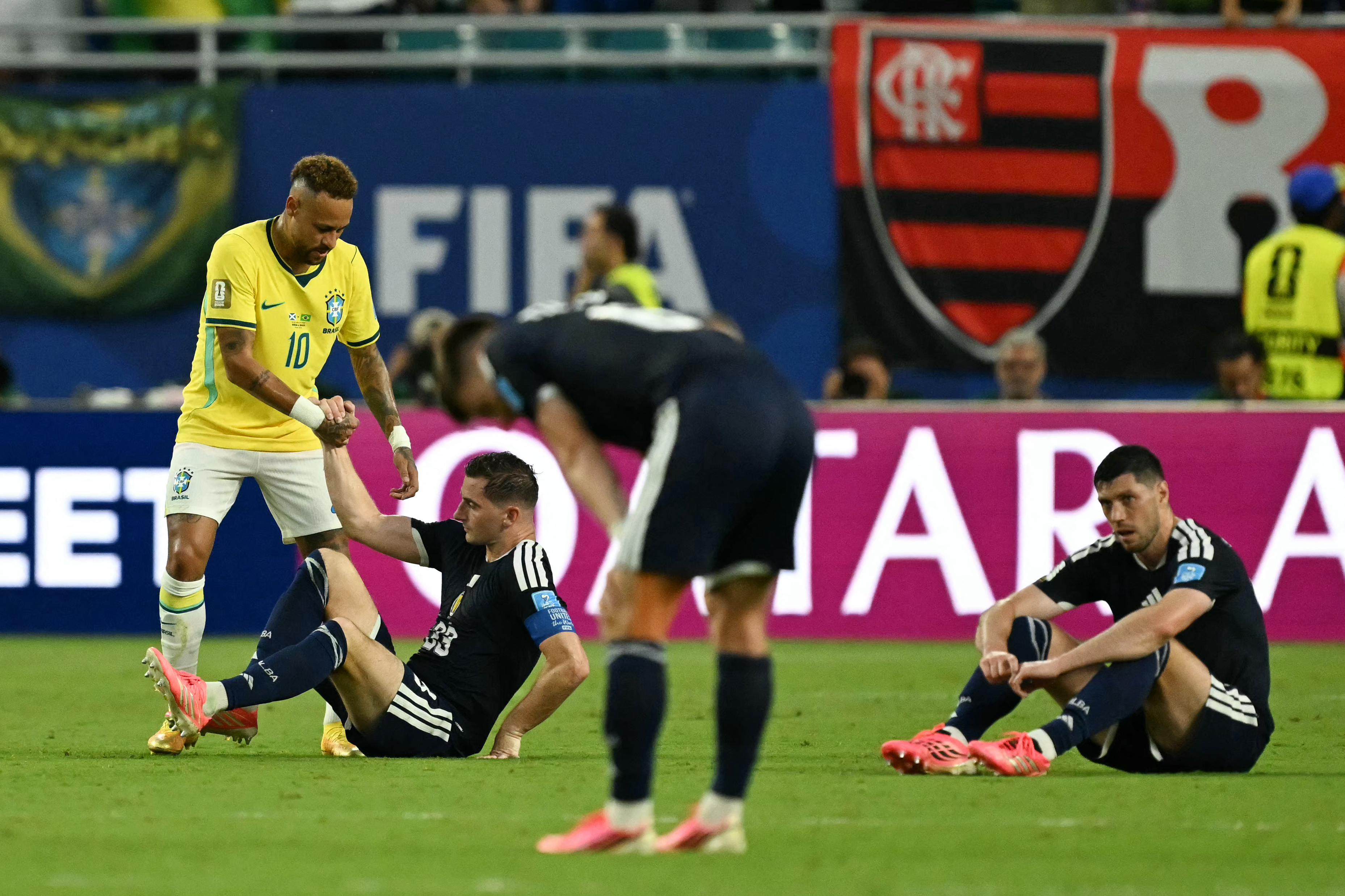 Brazil's Neymar helps Kenny McLean.