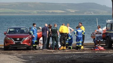 Off-duty volunteer rescues three people from water after boat capsizes