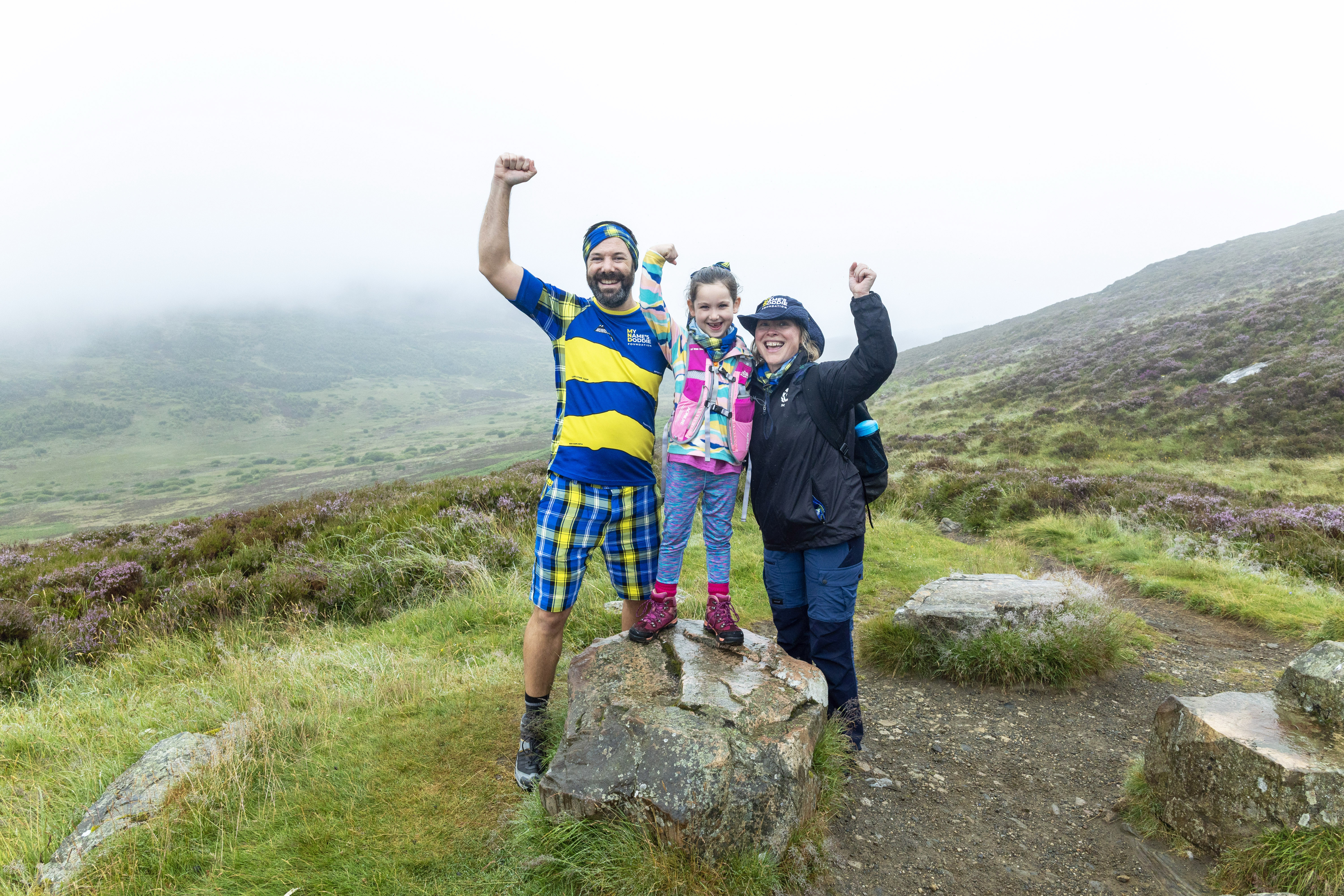 Paul Choat with his daughter Skye and Nicola Roseman chief executive of My Name5 Doddie Foundation on Schiehallion.