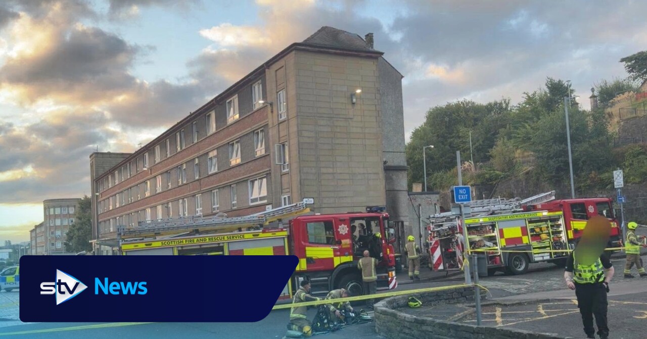Frau ins Krankenhaus gebracht, während Feuerwehrleute gegen einen Brand in ...