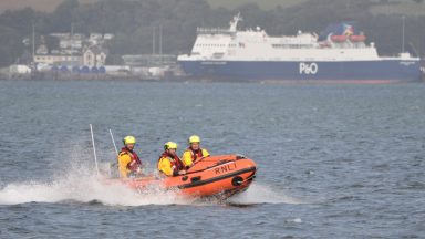 Off-duty volunteer rescues three people from water after boat capsizes